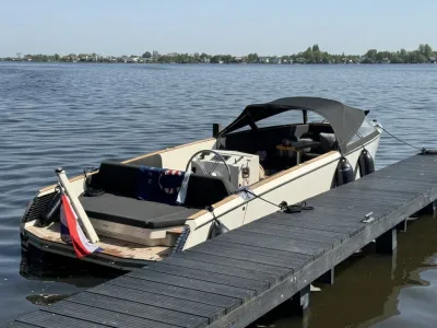 sloep aangemeerd bij houten steiger