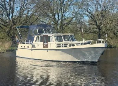 motorkruiser op rustig water, bomen op achtergrond