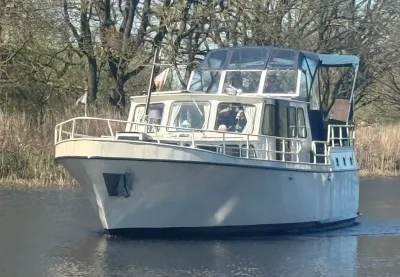 motorjacht op rustig water met bomen op achtergrond
