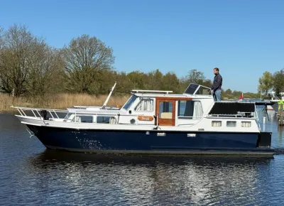 blauw-wit motorjacht op rivier