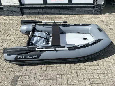 grijze opblaasboot met peddels op bestrating