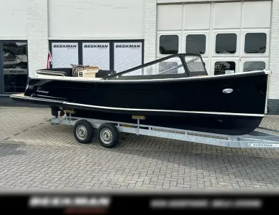zwarte sloep op trailer voor gebouw