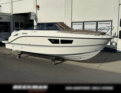 Witte sportboot op trailer voor gebouw