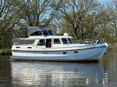 motorjacht liggend op rustig water bij bomen