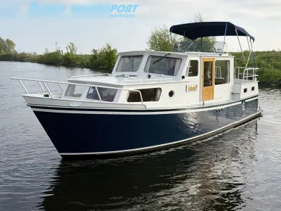 motorjacht op stil water bij groene oever