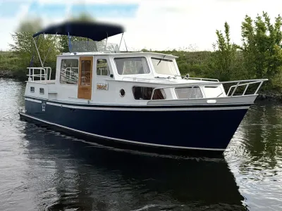 motorjacht aan de oever met bovendek en kajuit