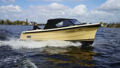 motorboot op open water met kap en bestuurder