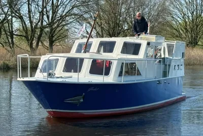 motorkruiser op rustig water bij bomen