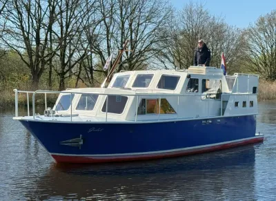 motorjacht op rustig water met bomen op achtergrond