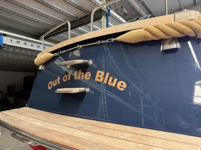 achterzijde van blauwe kajuitboot met naam