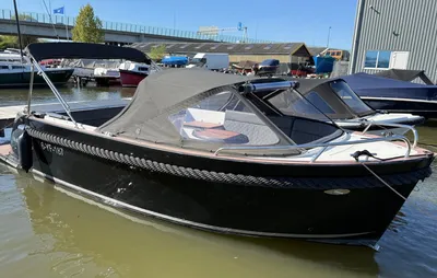 motorboot met kap afgemeerd in jachthaven