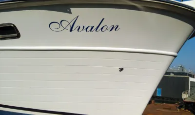 Boeg van wit jacht met naam