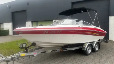 rood-witte bowrider op trailer bij pand