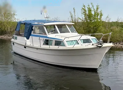wit motorjacht op rustig water bij oever