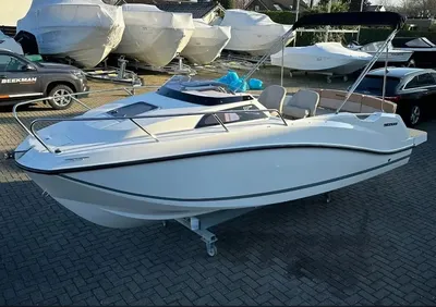 witte cabin-cruiser op parkeerterrein