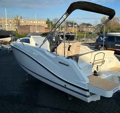 witte motorboot op trailer op parkeerplaats