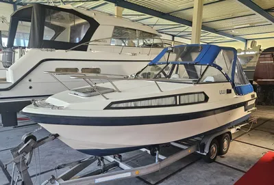 motorboot met kuiptent op trailer in loods