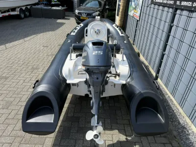 zwarte rib-boot met buitenboordmotor op parkeerplaats