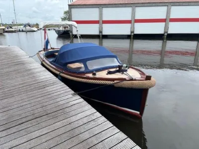 sloep aangemeerd bij houten steiger