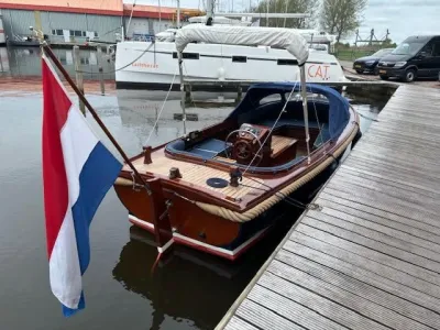 houten sloep aangemeerd bij een steiger