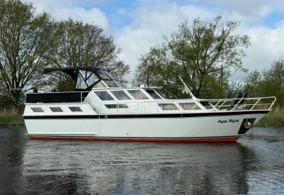 wit motorschip op water met bomen op de achtergrond