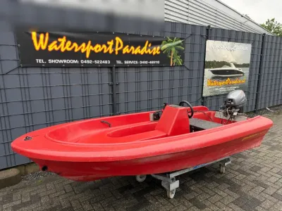 rode kleine boot op kar voor hek