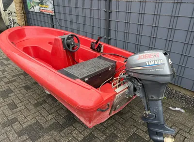 rode kleine open boot met buitenboordmotor