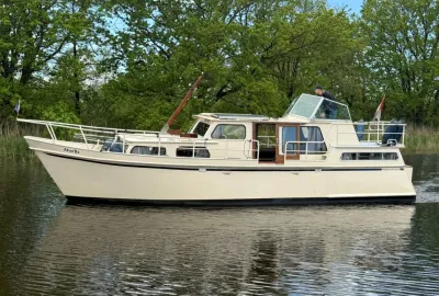 motorjacht op stil water met groene oever