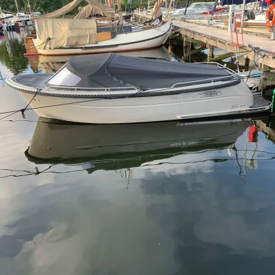 kleine motorboot met afdekzeil in jachthaven