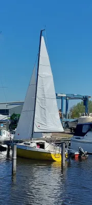 zeilboot in jachthaven met witte zeilen