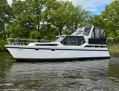 witte kruiser op water met bomen op achtergrond