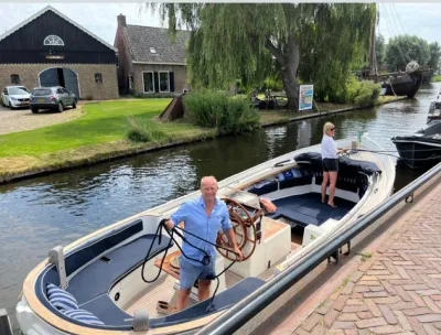 sloep in kanaal met twee personen