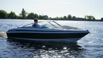 motorboot op een meer met bewoning op de oever