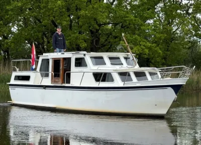 motorjacht op rustig water met persoon aan dek