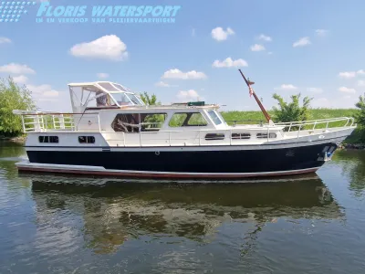 wit motorjacht aangemeerd op rustig water