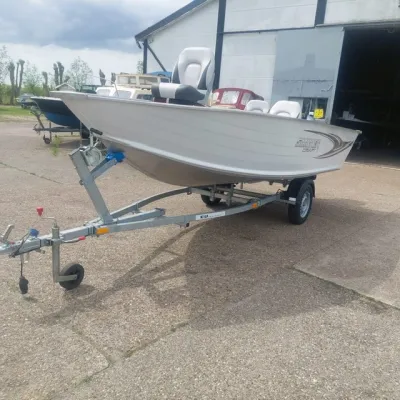 witte aluminium boot op trailer bij loods