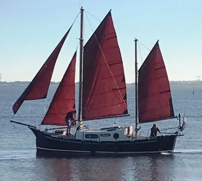 klassieke zeilsloep met rode zeilen