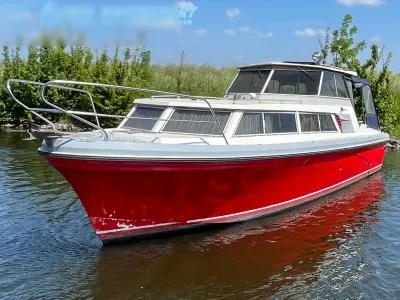 rood motorjacht in het water bij de oever