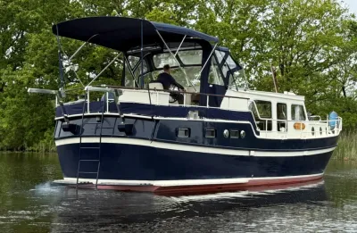 blauw motorjacht op water met bomen op achtergrond