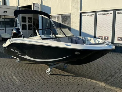 Zwarte sportboot op wielen bij showroom