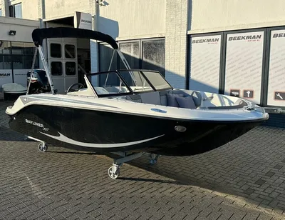 Zwarte sportboot op wielen bij showroom