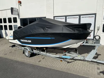 Consoleboot met afdekzeil op trailer bij showroom
