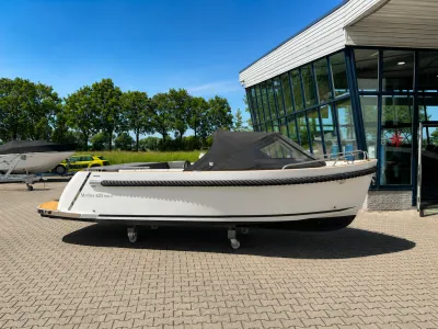 witte tender op parkeerplaats bij showroom
