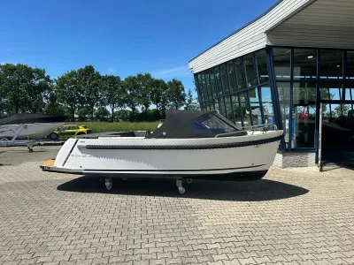 witte tender op parkeerplaats bij showroom