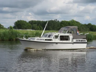 motorjacht varend op kanaal met oever