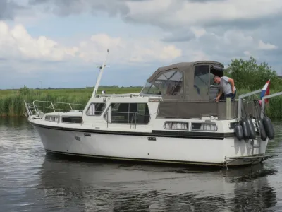 motorjacht op kalm water bij rietkraag