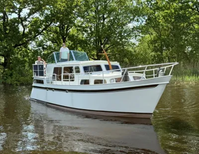 witte motorboot op rivier bij groene oever