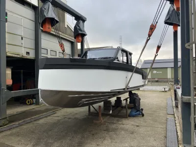 motorboot op werf hangend aan takels