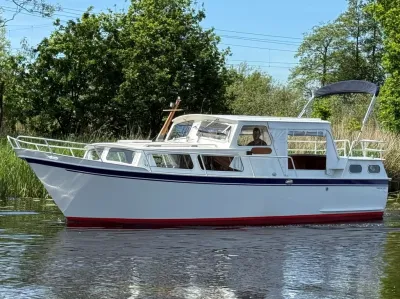 witte motorboot op kanaal met riet op oever