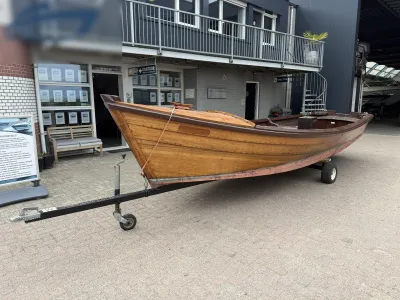 houten sloep op trailer voor gebouw